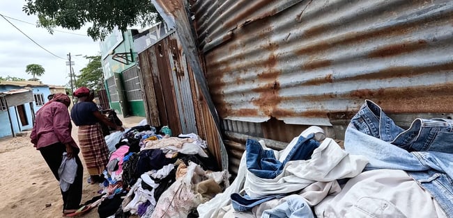 a group of people standing around a pile of clothes Xipamanine Maputo