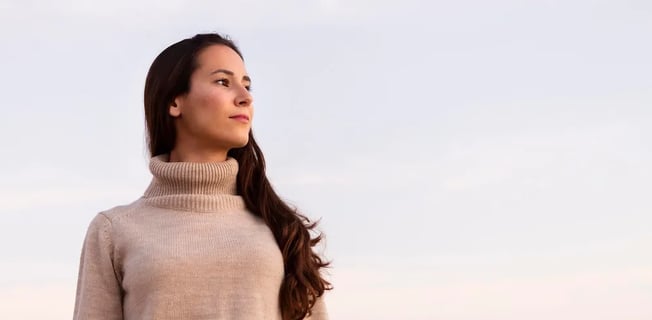 a woman in a turtle neck sweater and jeans