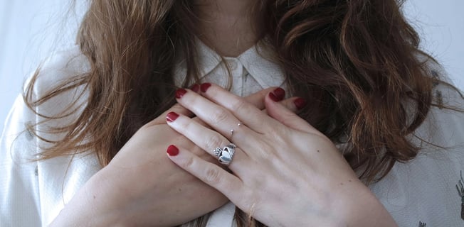 a woman with red nails and a ring on her finger