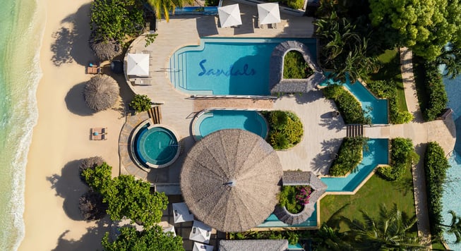 a beach resort with a swimming pool and a sandy beach