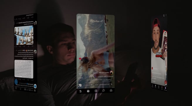 a man is laying in bed and holding a cell phone with social media apps running in front