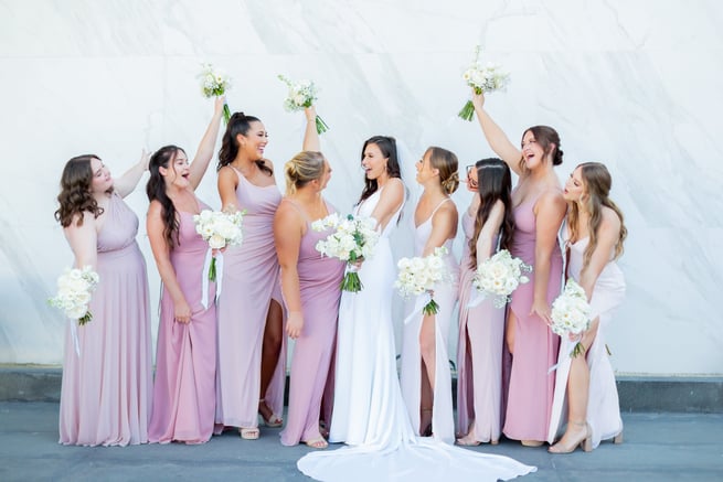 A moment captured by Los Cabos Wedding Films at the Garza Blanca Hotel in San José del Cabo: Bridesmaids raising their floral