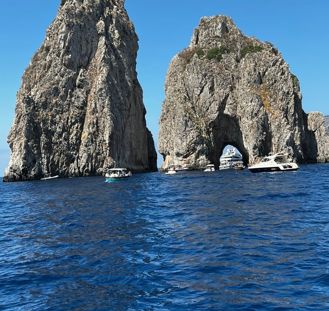 barco no mar próximo a um formação rochosa