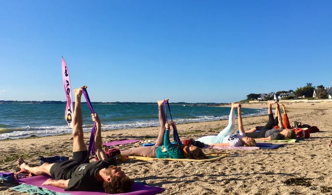 a group of people doing yoga on a beach