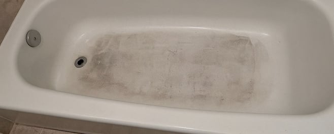 Bathtub before renovation for a restore and list your home project in DC, showing grime and wear pri