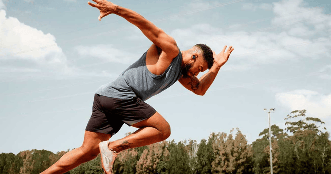a man in a gray tank top and shorts is running