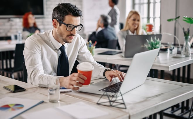 a man in a tie and a tie is sitting at a table with a cup