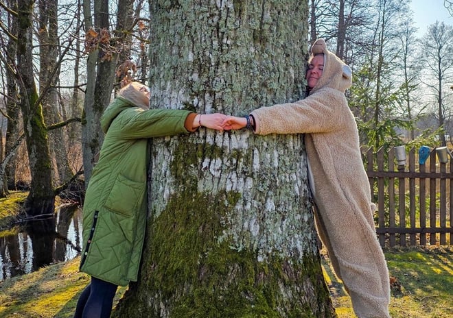 two women hugging the tree