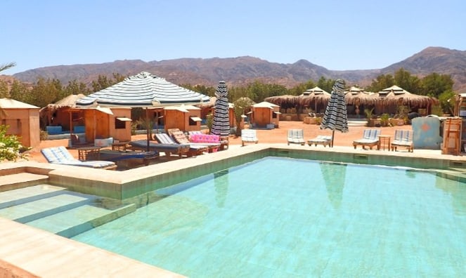 Platja amb piscina i gandules i para-sols