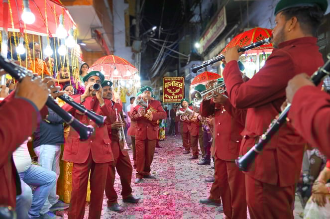 Manohar Brass Band, dressed in their traditional maroon attire and with all instruments, performing on the streets of Ajmer.