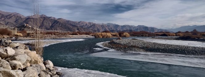 a river with ice and snow on the ground