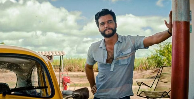 a man standing next to a yellow car