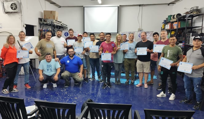 a group of people standing around a table with certificates. , Entrega de Certificados en ICL