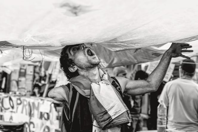 a man with a large umbrella in a tent