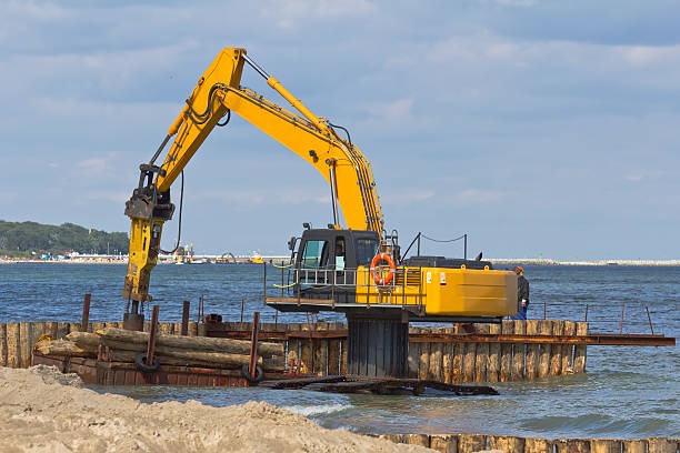 excavator holding logs for dock construction