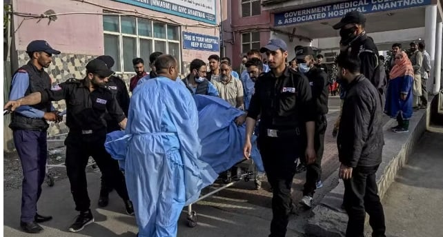 a group of people standing around a man in a blue blanket