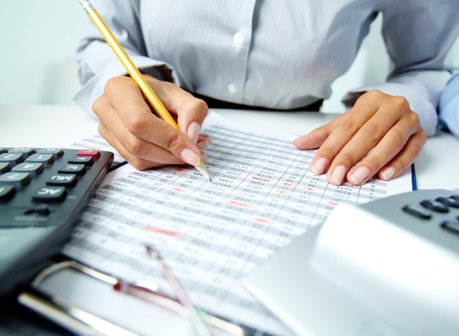 a person is holding a pencil and writing on a paper