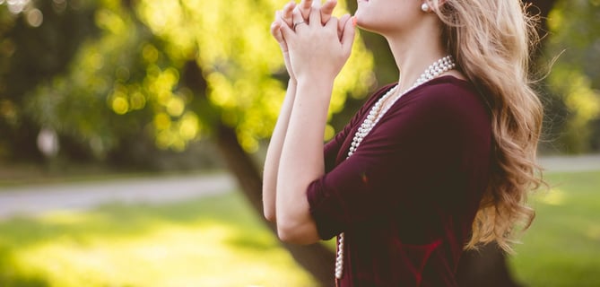a woman in a red dress is standing in the grass