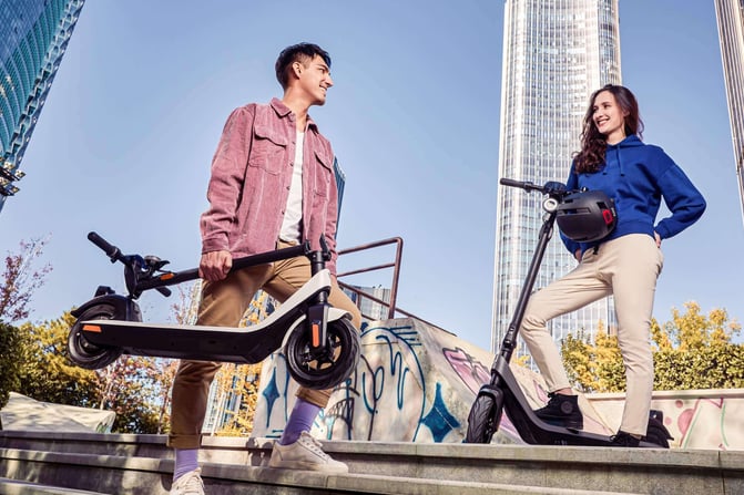 a man and woman standing on stairs with a scooter