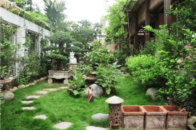 a garden with a stone path and a statue of a man