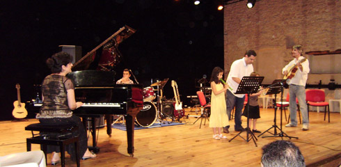 a group of people standing around a piano