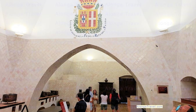 An enormous kitchen with the Queen Maria Pea the coat of arms on the wall. 