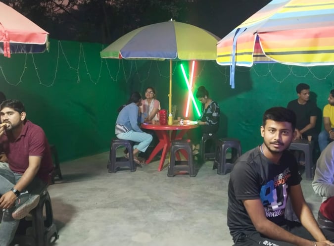 a group of people sitting at a table with umbrellas