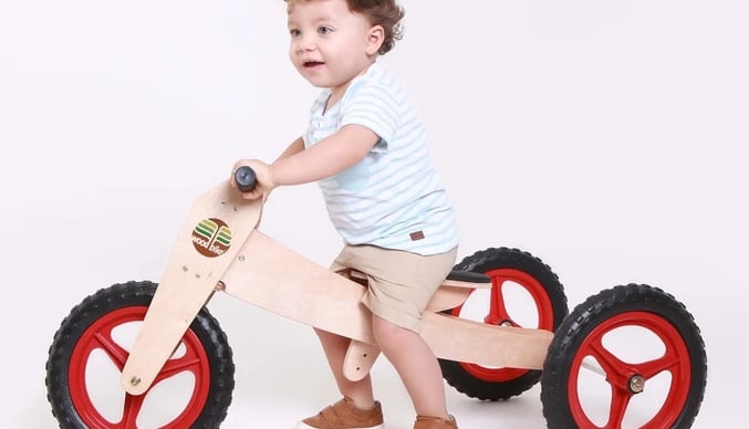 bebê em bicicleta de madeira