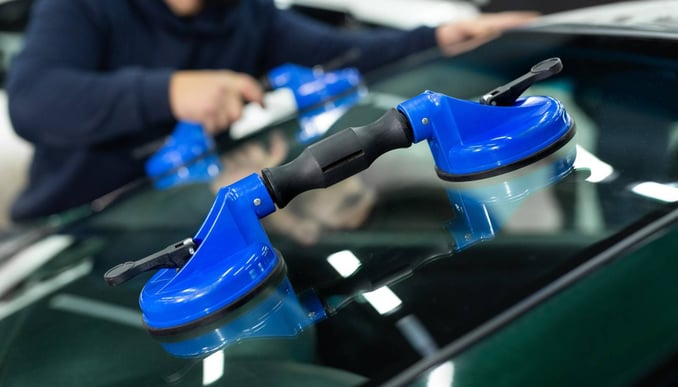 a man is cleaning a car with a blue handle