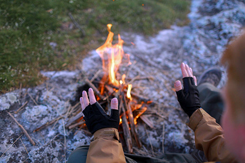 warming hands next to a newly started fire