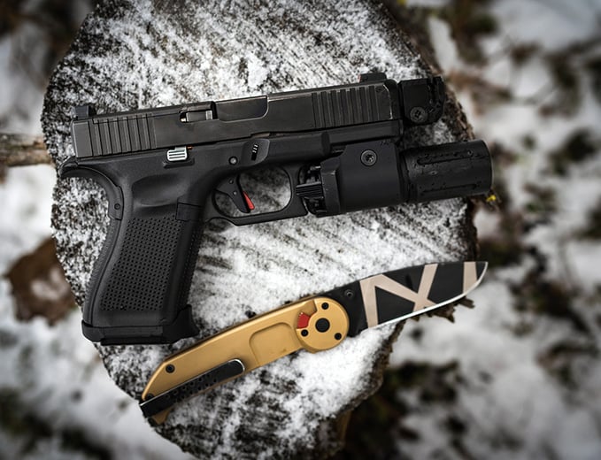 Glock pistol and knife on snow covered tree stump