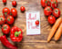 A notepad with "Meal Plan" written on it, surrounded by fresh vegetables on a wooden table.