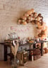 Un mur en brique décoré de ballons et guirlande.Une table avec des bocal à bonbons