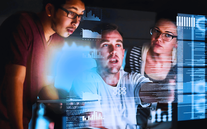 Male leader discussing data with a man and a woman on a computer screen