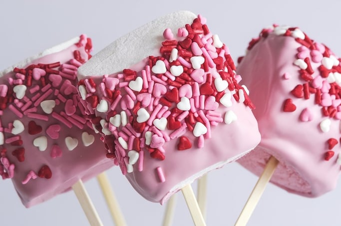 Large marshmallows dipped in pink chocolate and covered with heart-shaped sprinkles