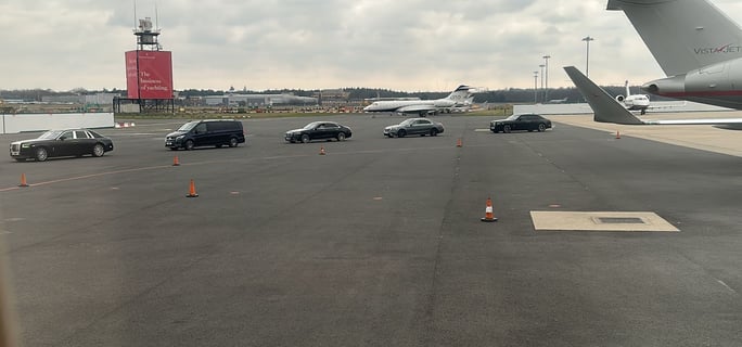 a plane is parked on the runway at an airport with cars driving towards it