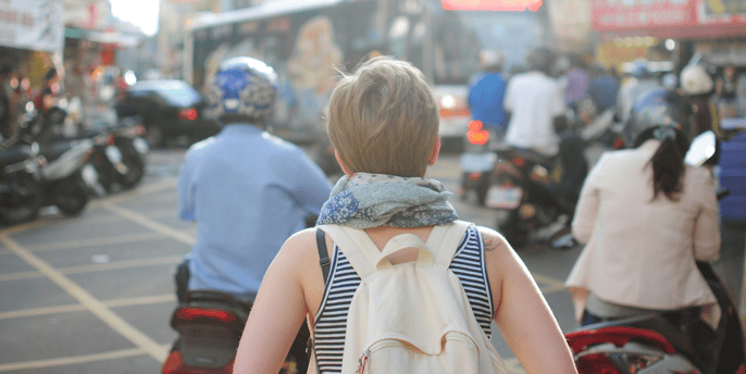a woman walking down a busy street in a busy city
