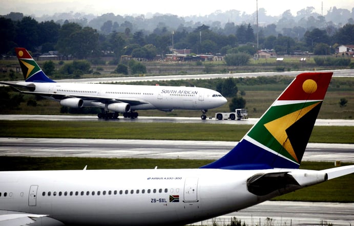 two airplanes are parked on the runway at an airport,Acsa