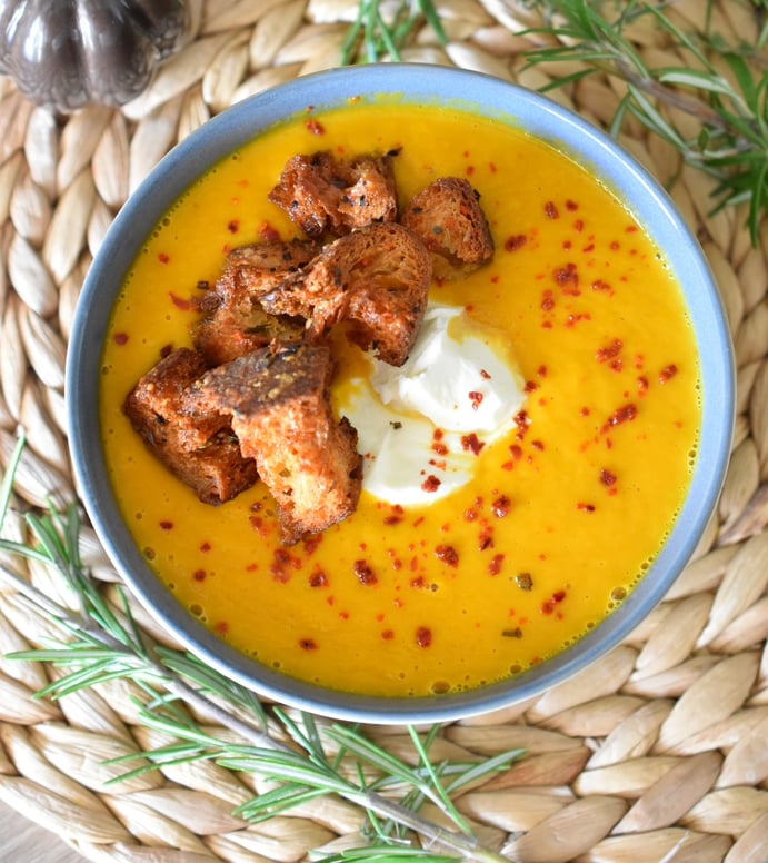 a bowl of soup with croutons and cream