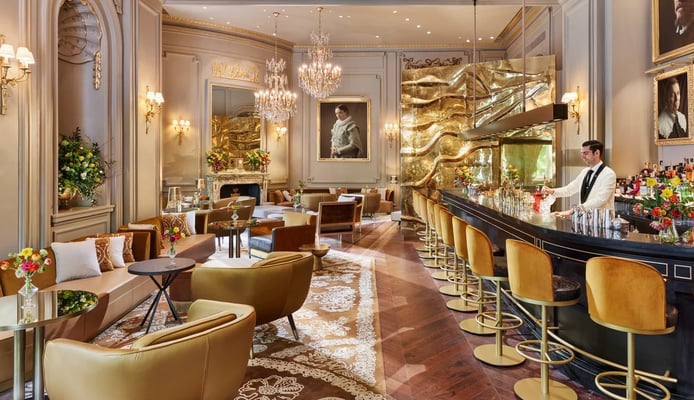 Pictura Bar – Luxurious cocktail bar with golden accents, plush seating, and classic artwork.