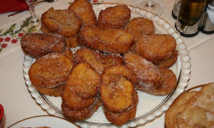a plate of rabanada and a glass, food table