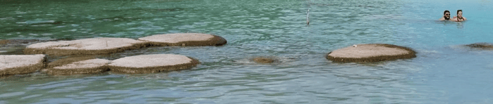 two people are swimming in a body of water