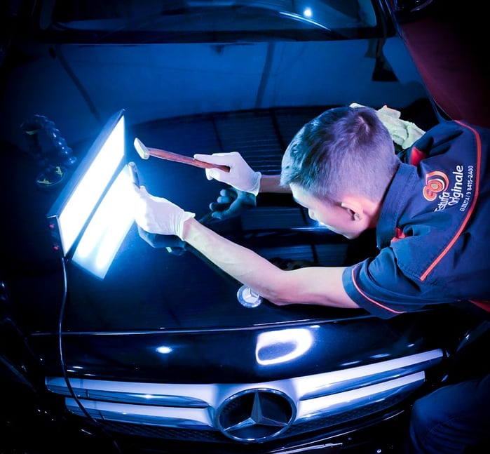 Colaborador da Estufa Originale executando o martelinho de ouro em uma Mercedes preta