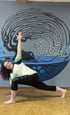 Rachel yoga pose in front of blue water mural