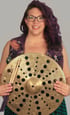 Rachel holding a cymbal with holes through out it, smiling