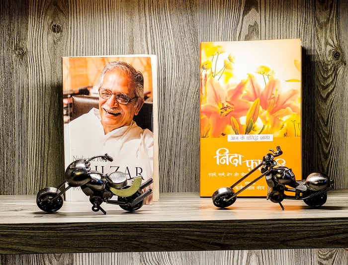 Aesthetic bookshelf with poetry books and metal motorcycle miniatures.