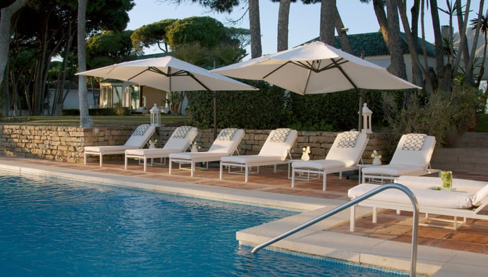 Pool area at Villa El Rincon in Marbella with ocean views, designer furnishings, and open-concept Mediterranean design