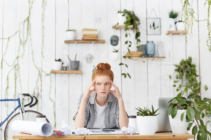 a woman sitting at a desk with a tablet