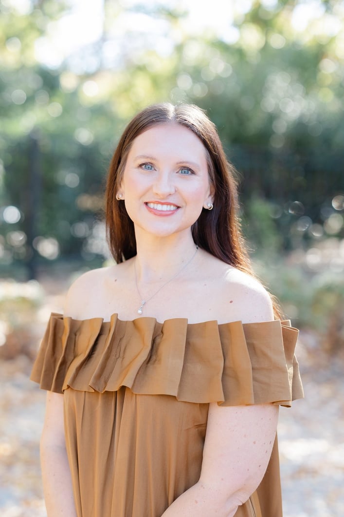 A white woman with brown hair smiling