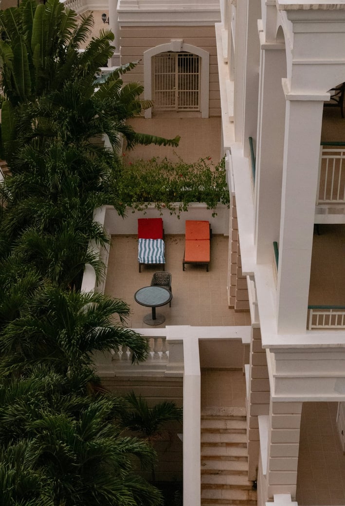 a balcony with a table and chairs in the middle of the room